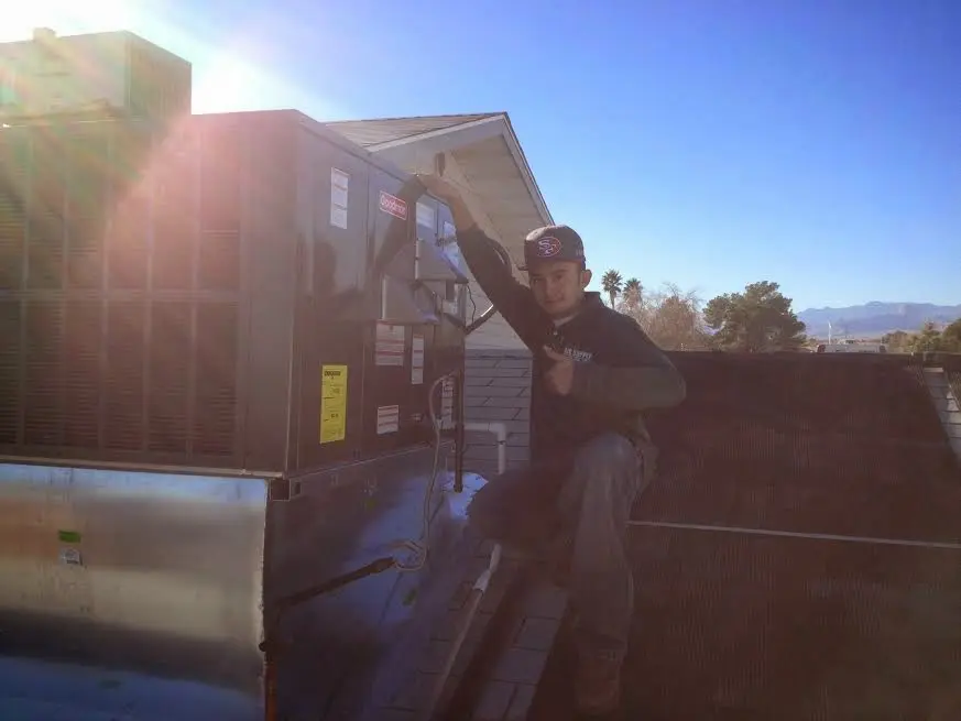HVAC technician performing AC Tune-Up on a rooftop unit in Kirkland